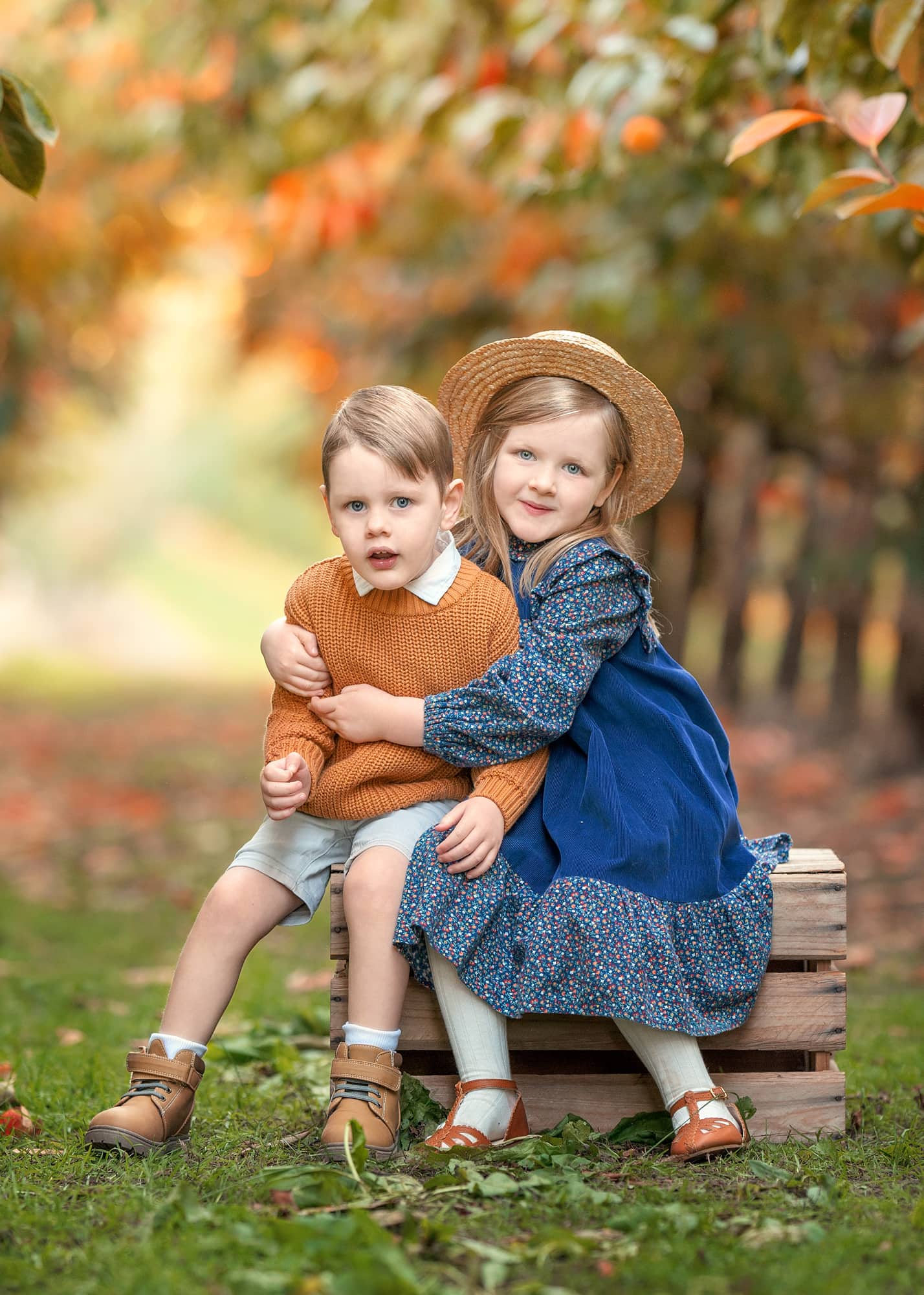 Perth toddlers sitting on a crate during autumn family photoshoot at Raeburn Orchard