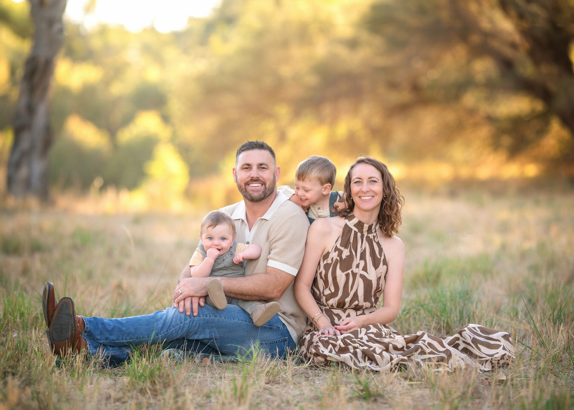 Tips for hiring a family photographer. 2 year old toddler and 7 month old baby with parents during outdoor family photoshoot.